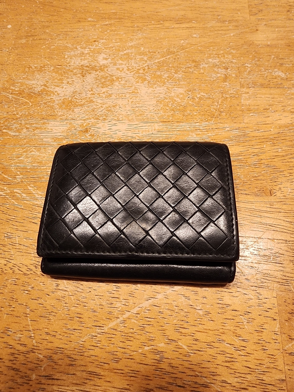 black Bottega Veneta leather wallet featuring the signature Intrecciato woven